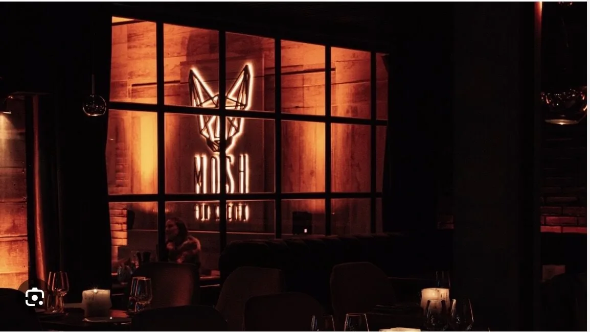 Mosh Fun Kitchen Marbella, club de lujo con cena, logotipo de zorro de neón y elegante interior para cenas íntimas