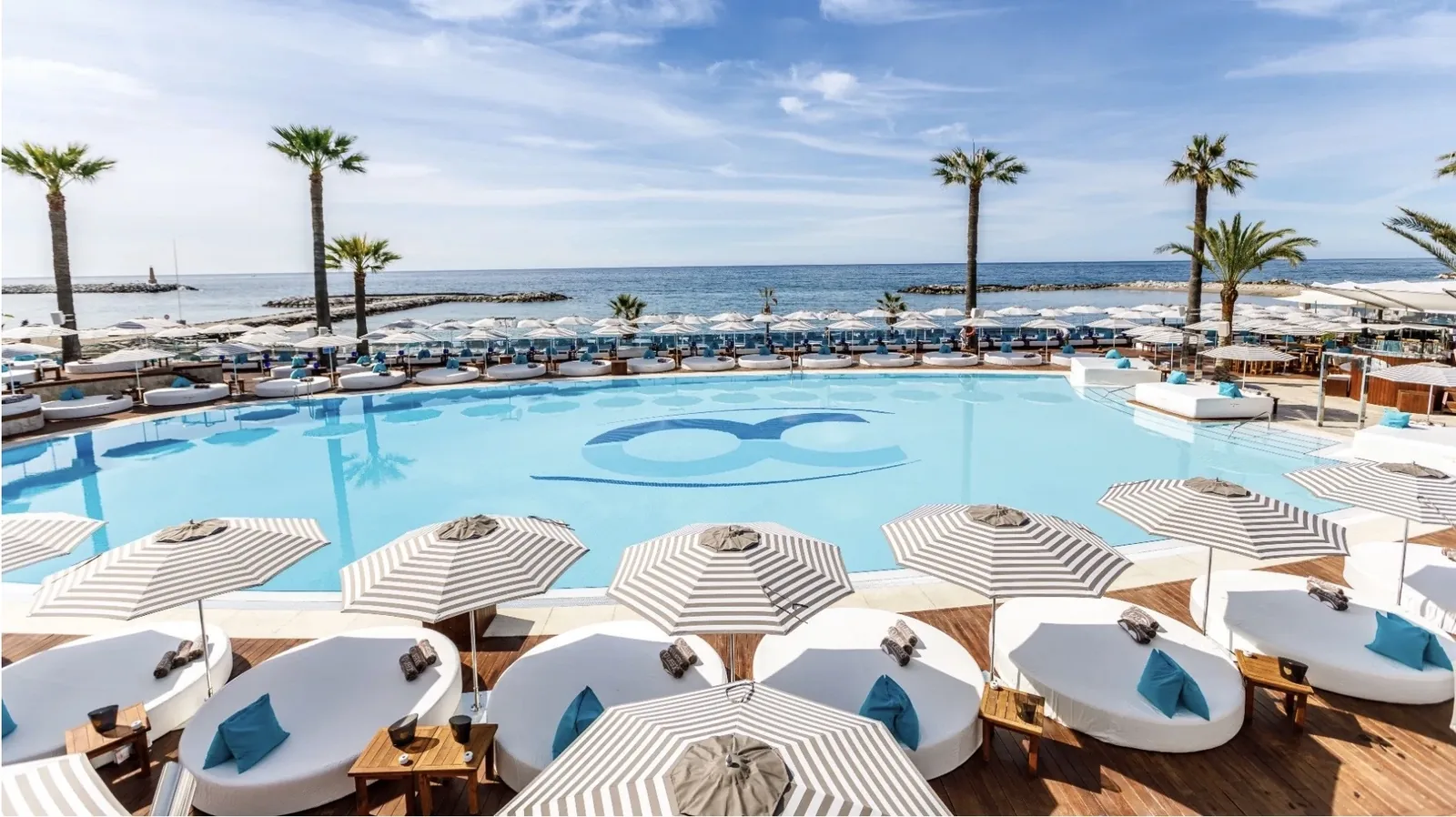Exclusivo Ocean Club Marbella con icónica piscina circular de agua salada, tumbonas VIP blancas y magnums de champán
